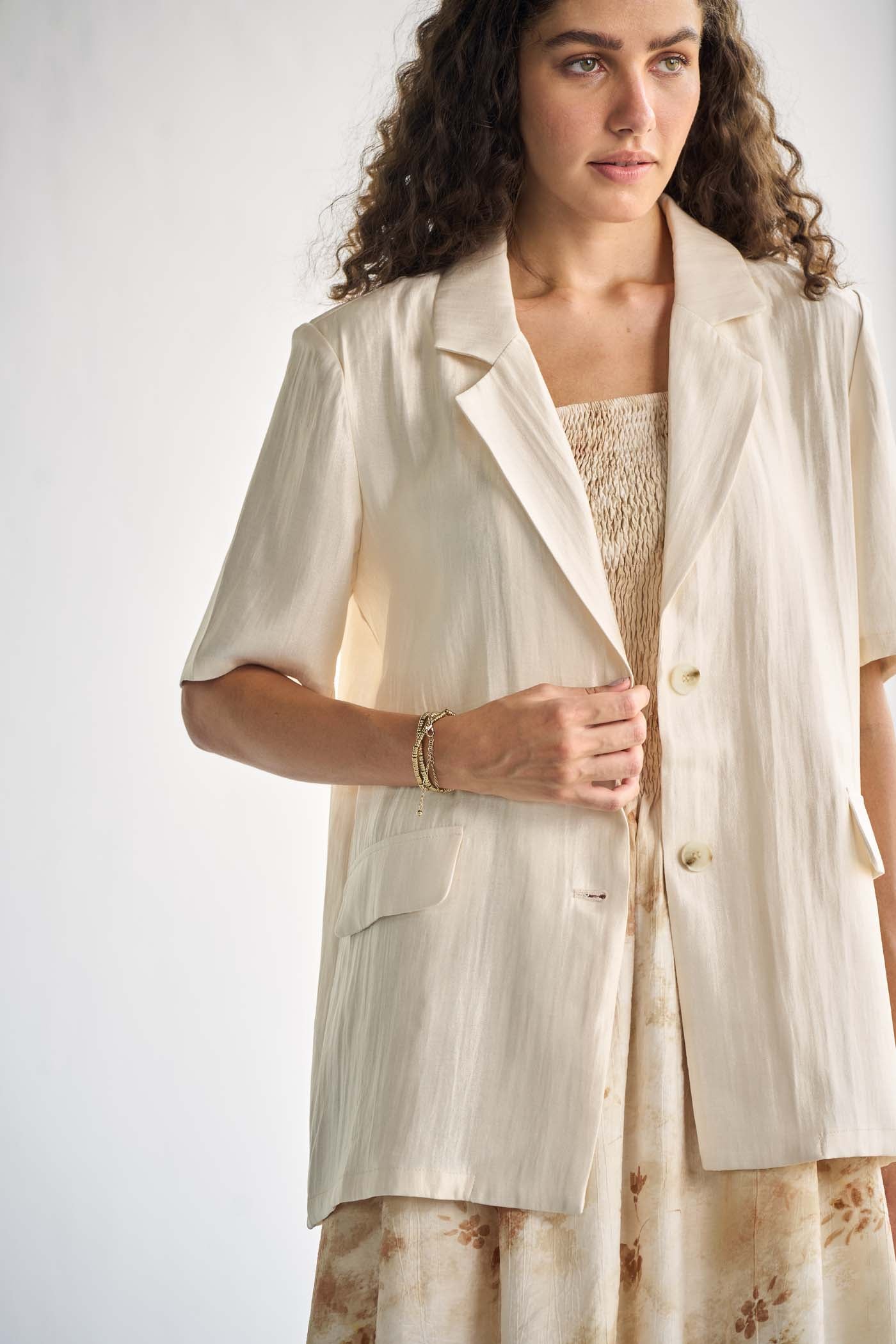 Ivory-tone blazer with notched lapels.