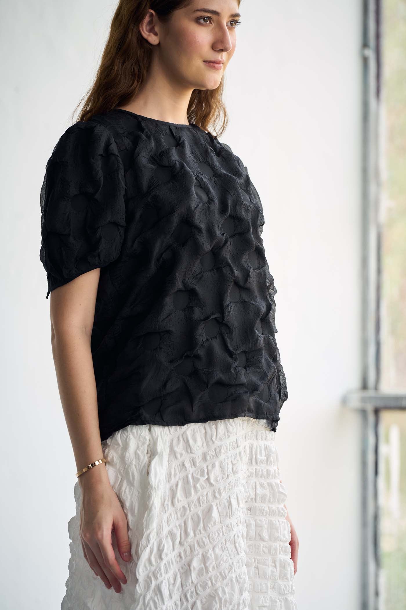 Black textured top paired with white textured skirt