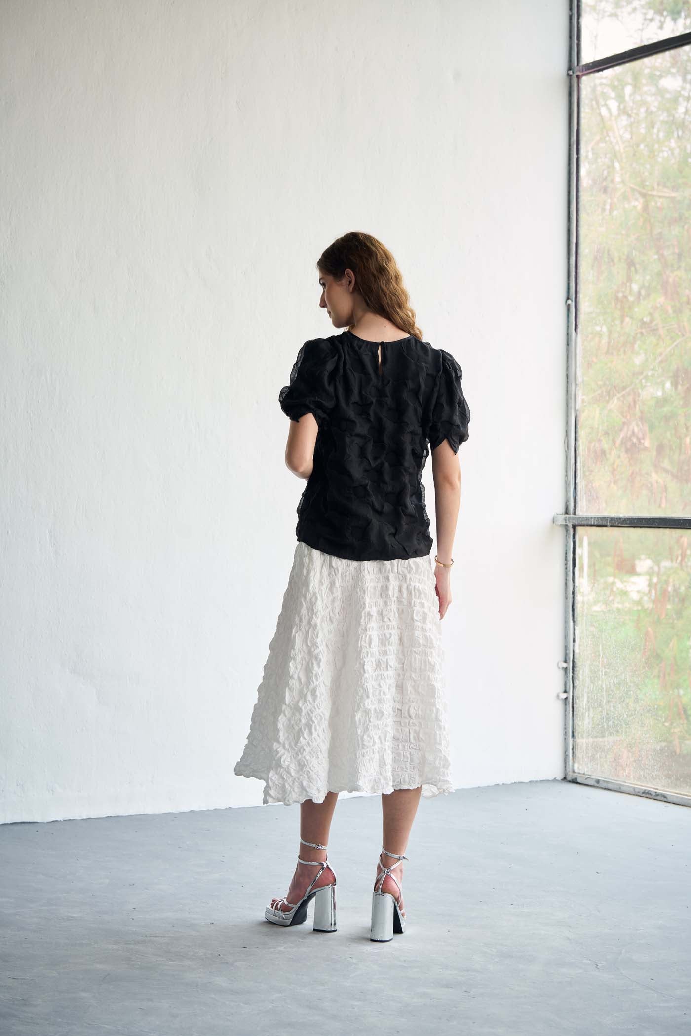 Black textured top paired with white textured skirt